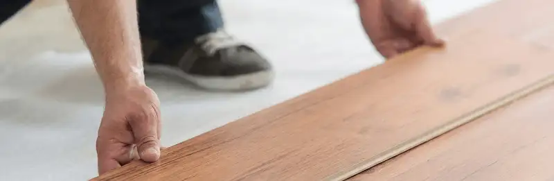 A professional installing laminate flooring in Fresno, CA